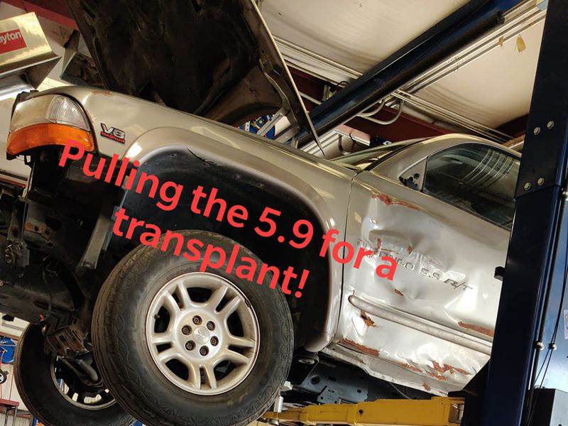 Dodge on a lift with the 5.9 being pulled for the transplant