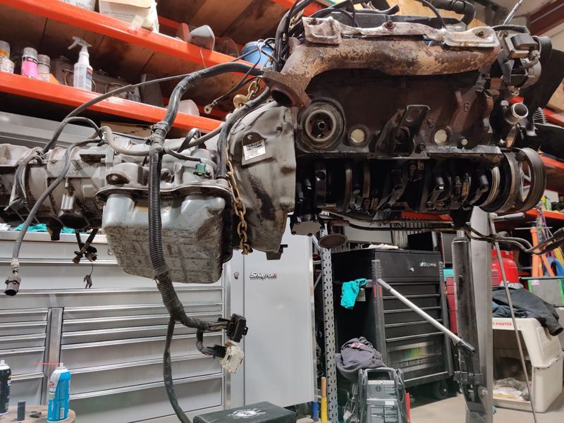 The 5.9 V8 and transmission hanging from a hoist